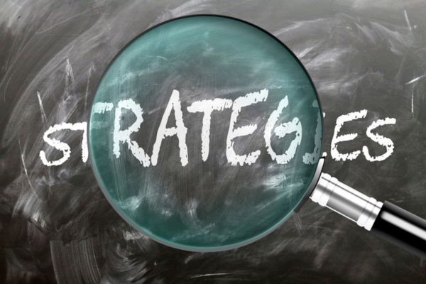 STRATEGIES written on a chalkboard highlighted by a magnifying glass