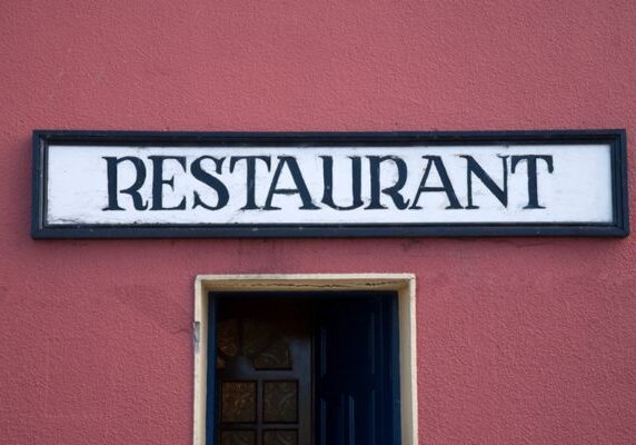 restaurant sign on a wall above the door