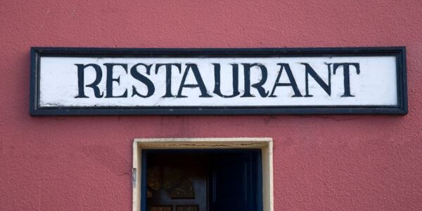 restaurant sign on a wall above the door